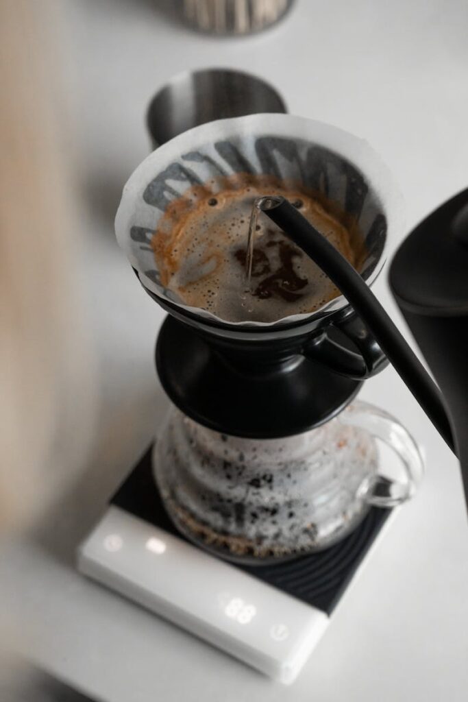 Close-up of a precision pour over coffee brewing process with a kettle and scale.